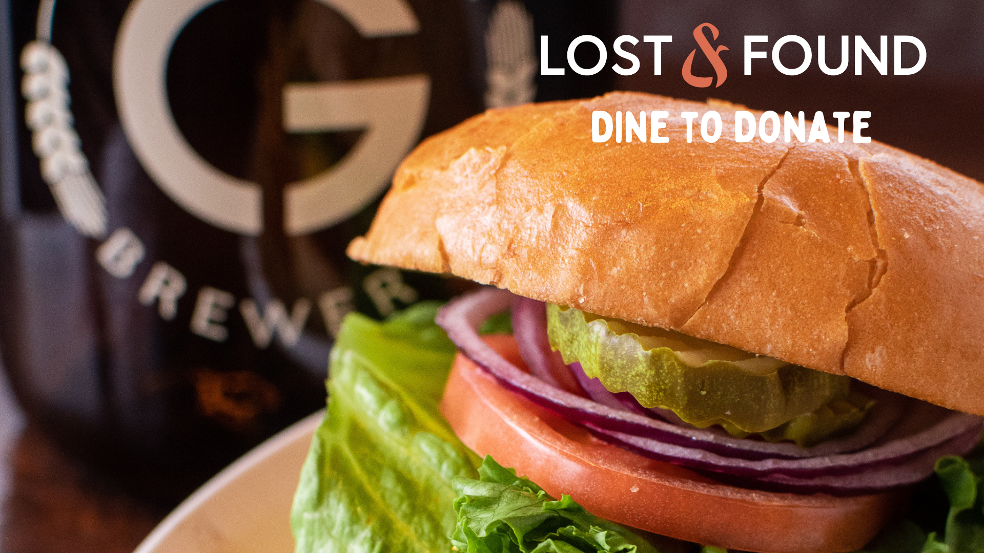Close-up photo of a burger and growler of beer. Text overlay shows the Lost&Found logo and the words "dine to donate".